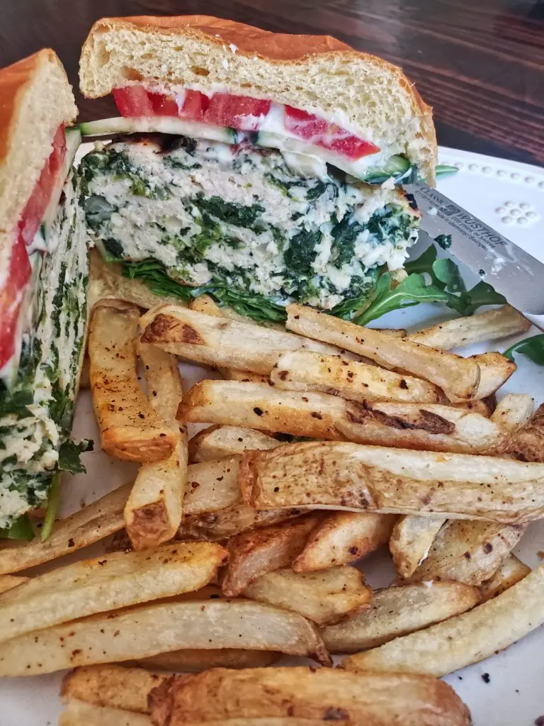 spinach and feta turkey burger sliced in half with french fries