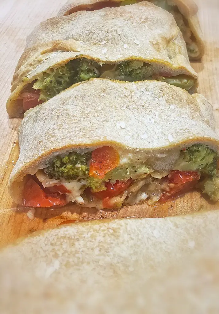 broccoli tomato and cheese stromboli sliced into pieces