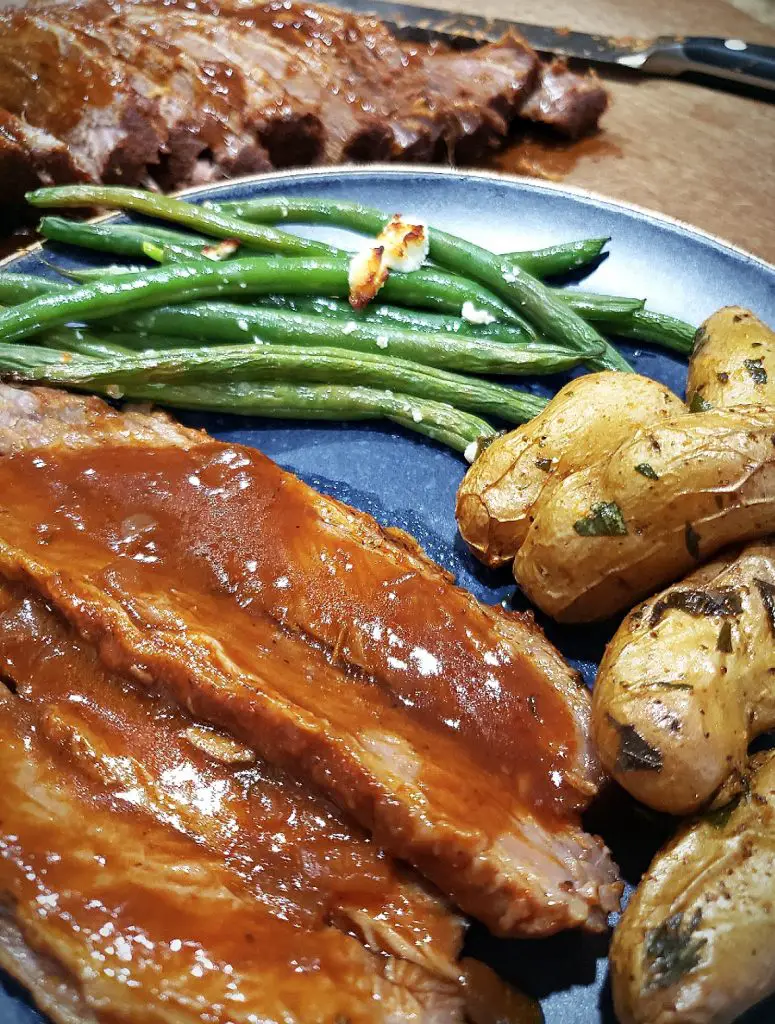 slice brisket with gravy and roasted potatoes and green beans