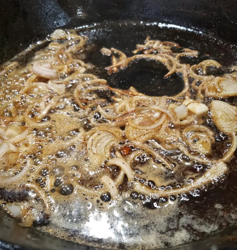 sliced shallots in cast iron skillet deglazed by white wine