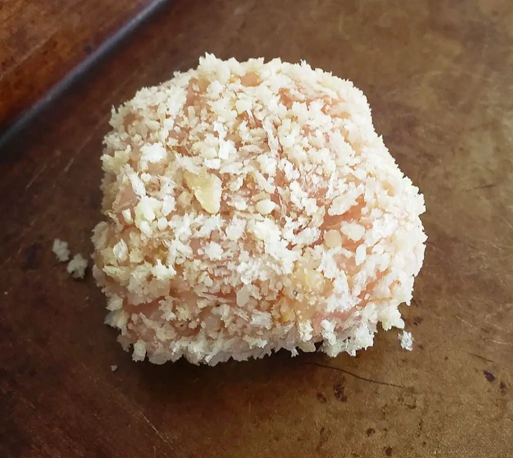 uncooked chicken nugget coated in panko breadcrumb and parmesan