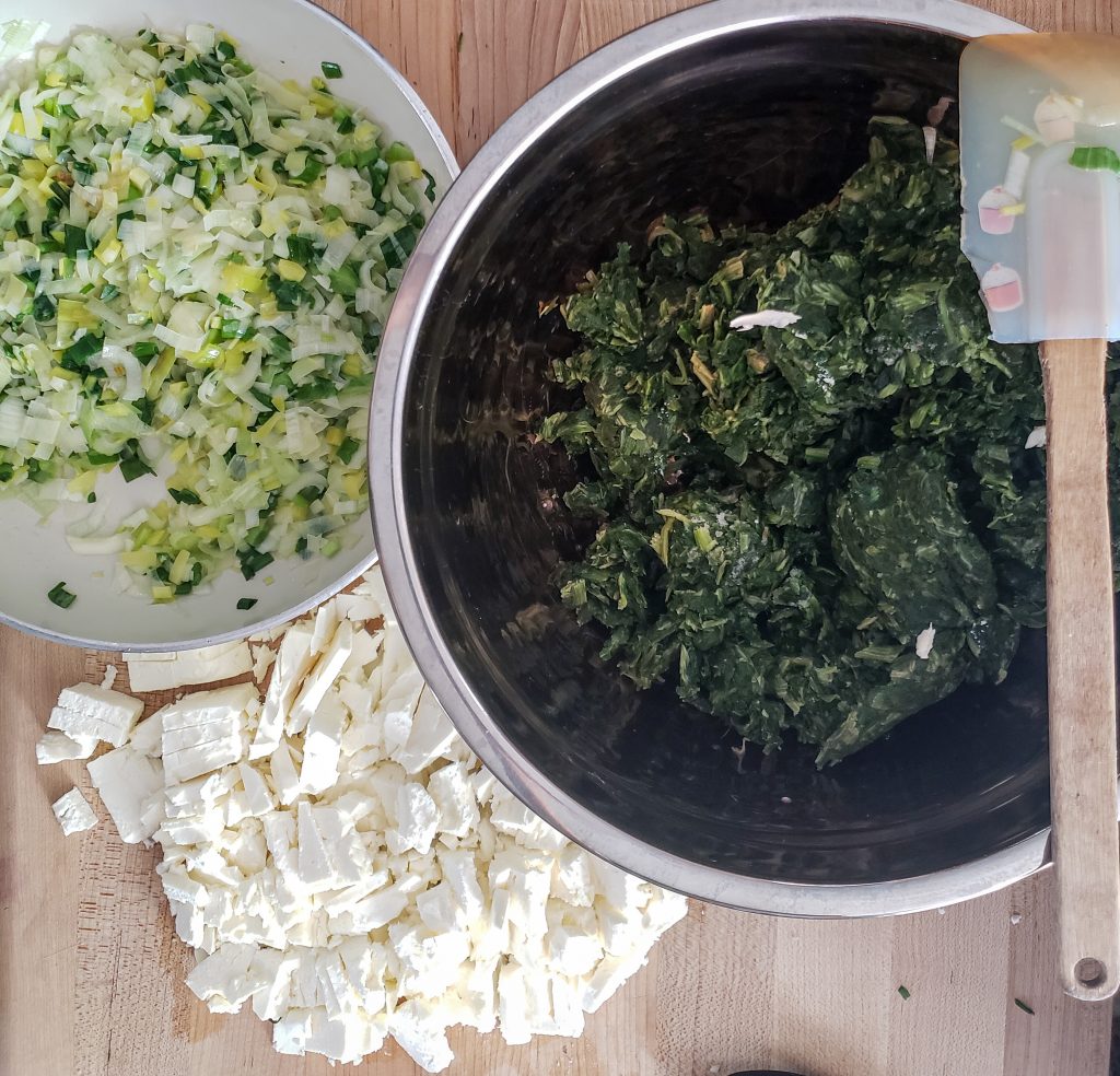 spanakopita spinach feta pie filling being assembled