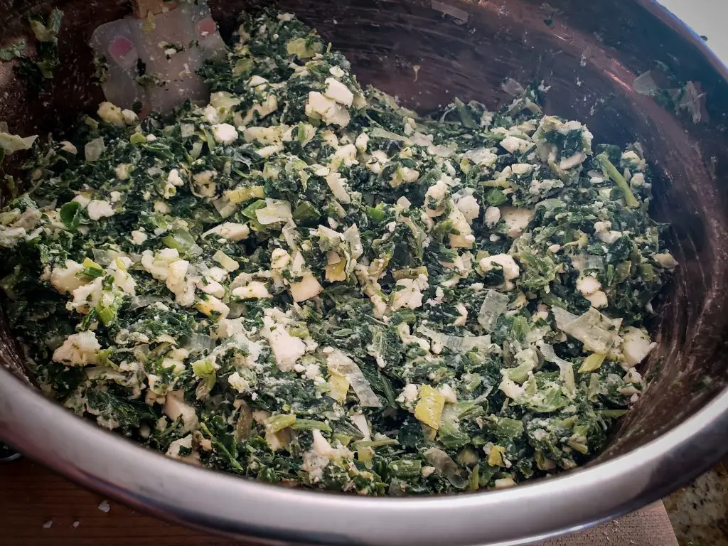 spanakopita spinach feta pie filling in mixing bowl
