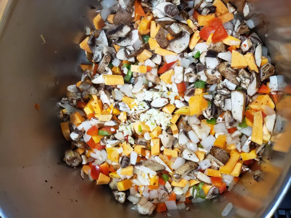 chopped onions, sweet potatoes, mushrooms, jalapeno, bell pepper, garlic in pot as base for vegan chili