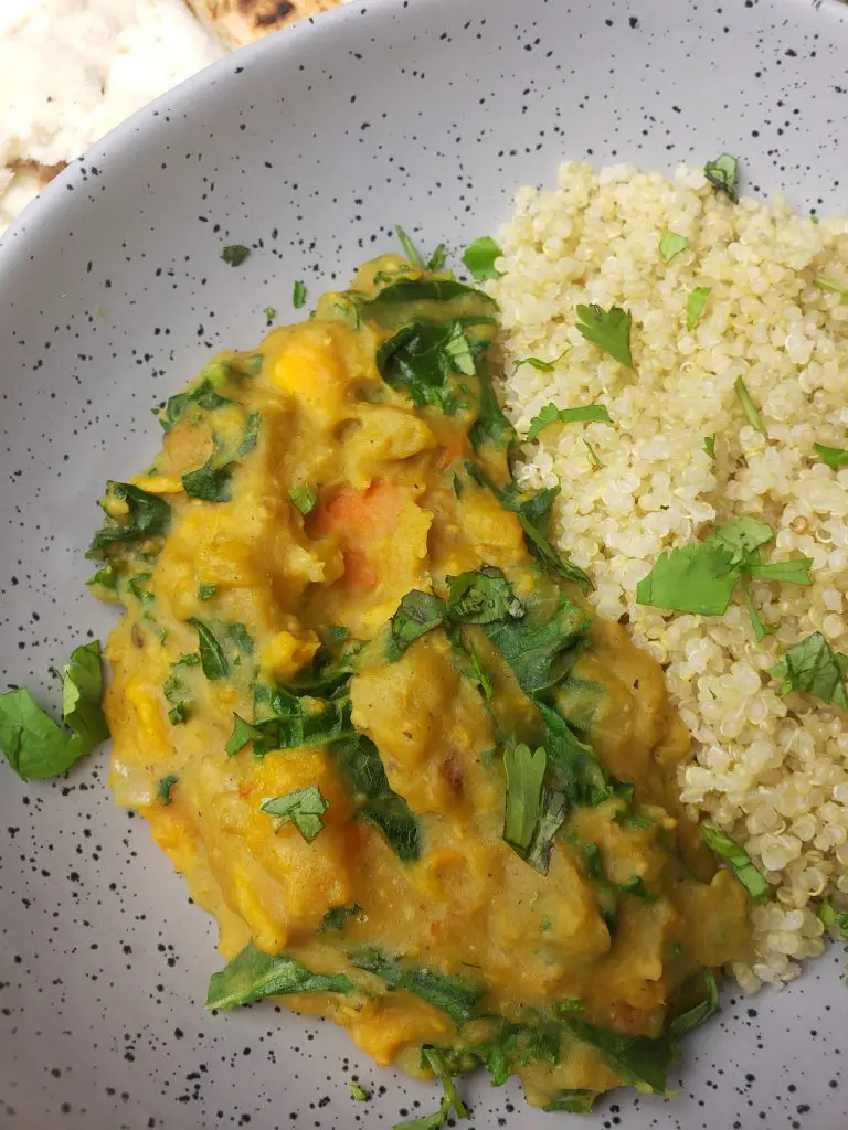 instant pot sweet potato red lentil coconut curry served with a side of quinoa