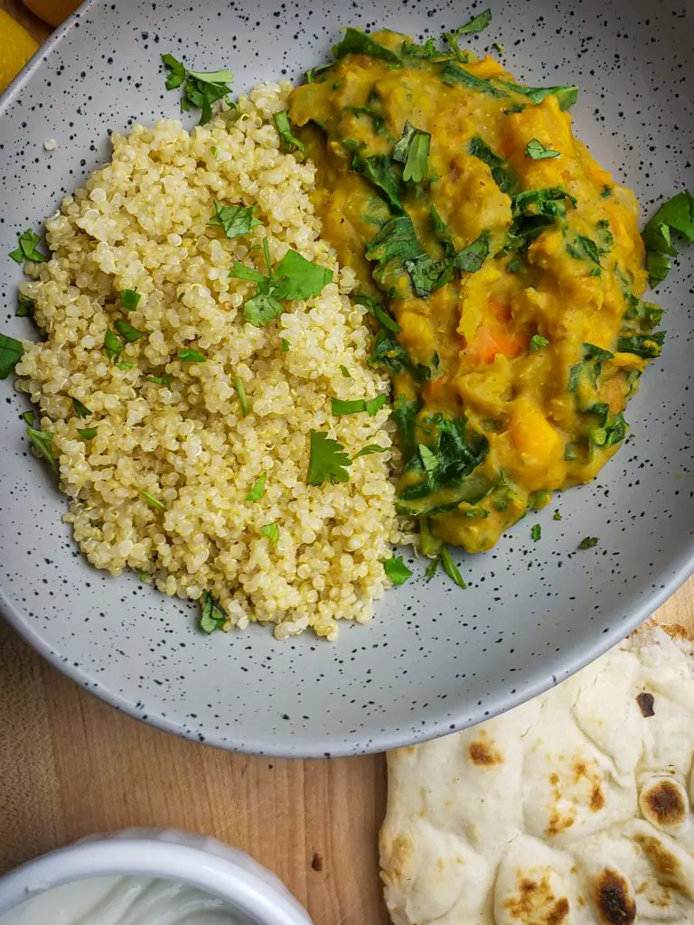 instant pot sweet potato red lentil coconut curry served with a side of quinoa