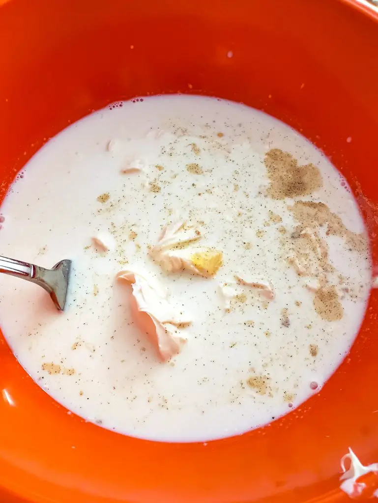 overhead image of mixing bowl of milk, pepper, salt mustard powder and marscapone cheese to make lazy mom mac and cheese
