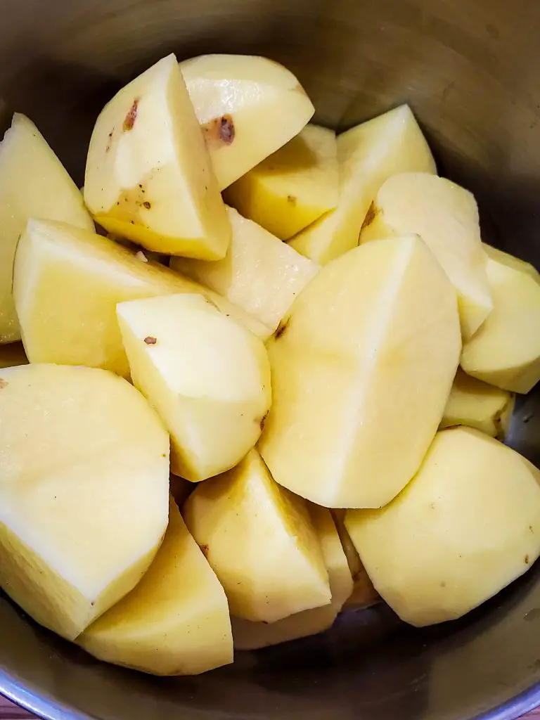 image of peeled and quartered yukon gold potatoes in pot