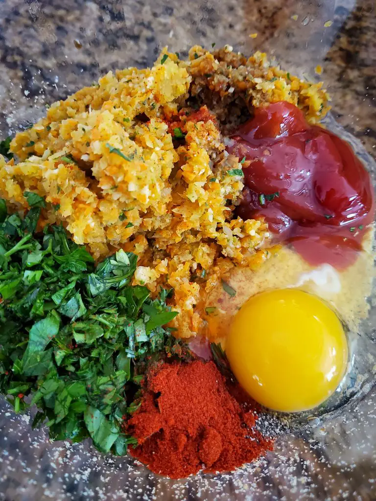 image of mixing bowl with spices and minced vegetables to make mini meatloaf with tomato glaze