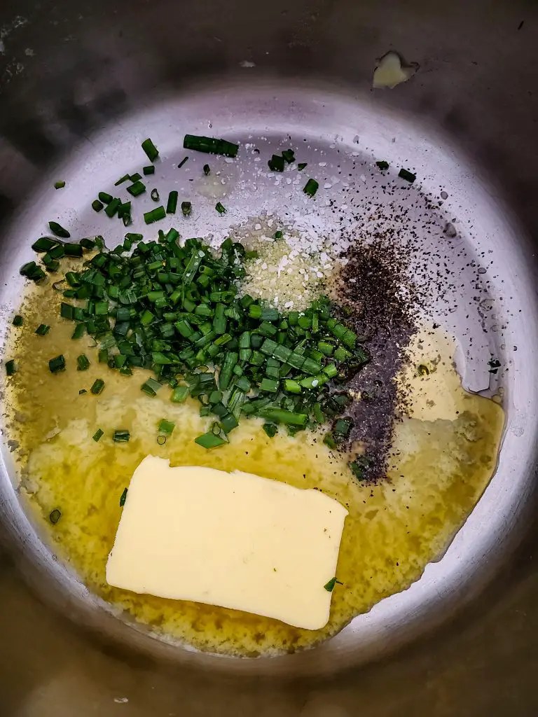 image of melted irish butter with chives and salt and pepper in a pot