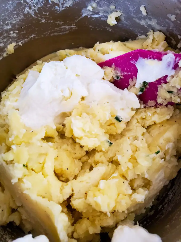 image of irish butter mashed potatoes being mixed in pot with greek yogurt