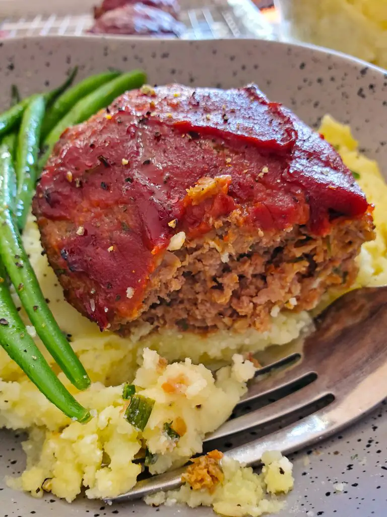 image of dinner serving of meatloaf and mashed potatoes with green beans in shallow bowl