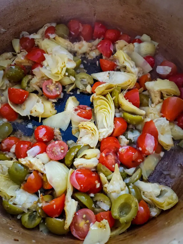 image of olives, artichoke hearts , cherry tomatoes in dutch oven 