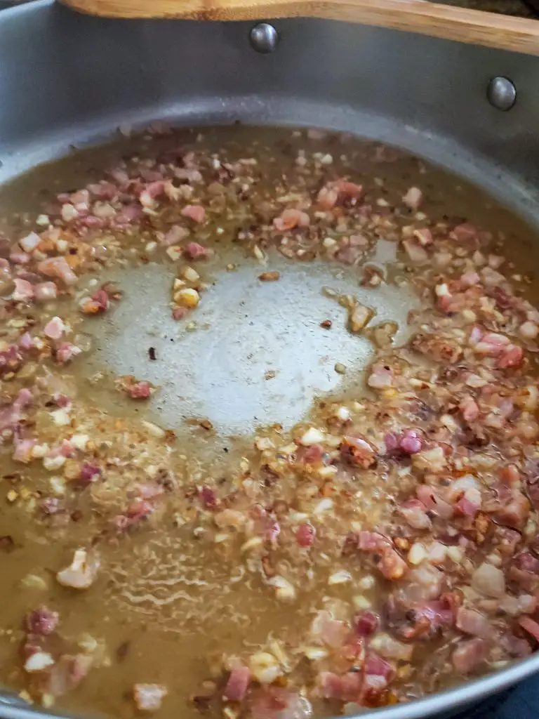 image of sauteed shallots and pancetta deglazed with vodka in pan