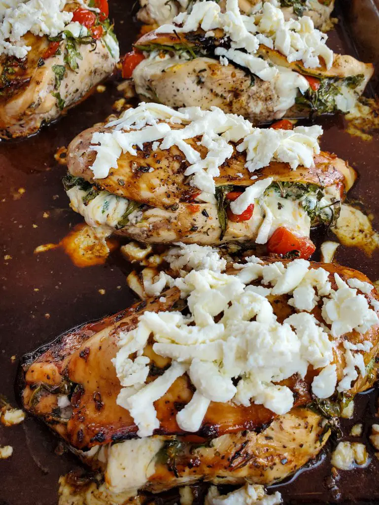 image of baked caprese stuffed chicken breasts with balsamic glaze topped with shredded fresh mozzarella cheese