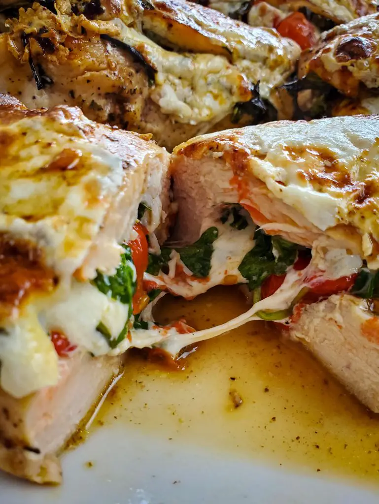 image of caprese stuffed chicken bread cut in half on plate