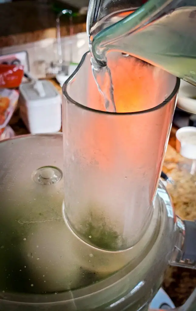 image of water added to food processor for pea and mint pesto