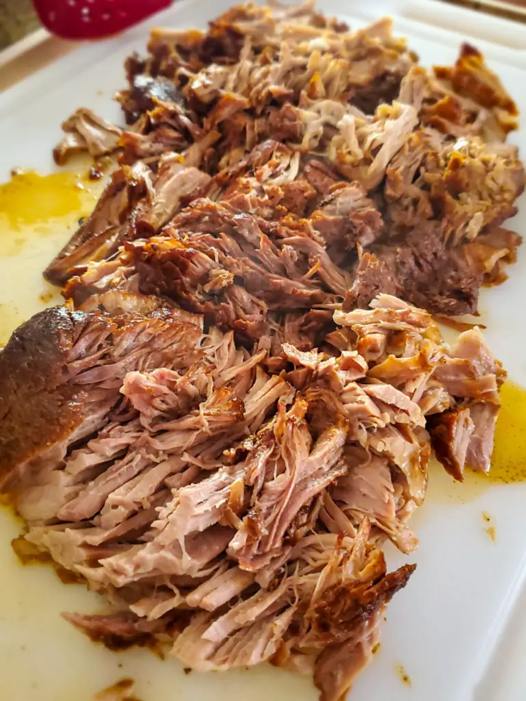 shredded pulled pork on cutting board