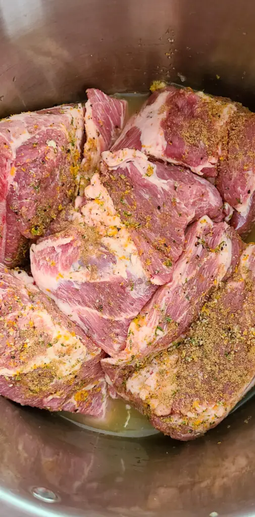 cubes of pork butt with seasoning in instant pot with cooking liquid