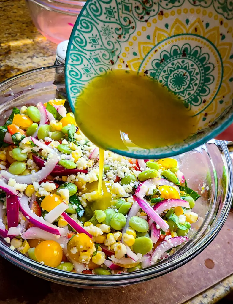 pour simple dressing over lima bean and grilled corn salad and toss together