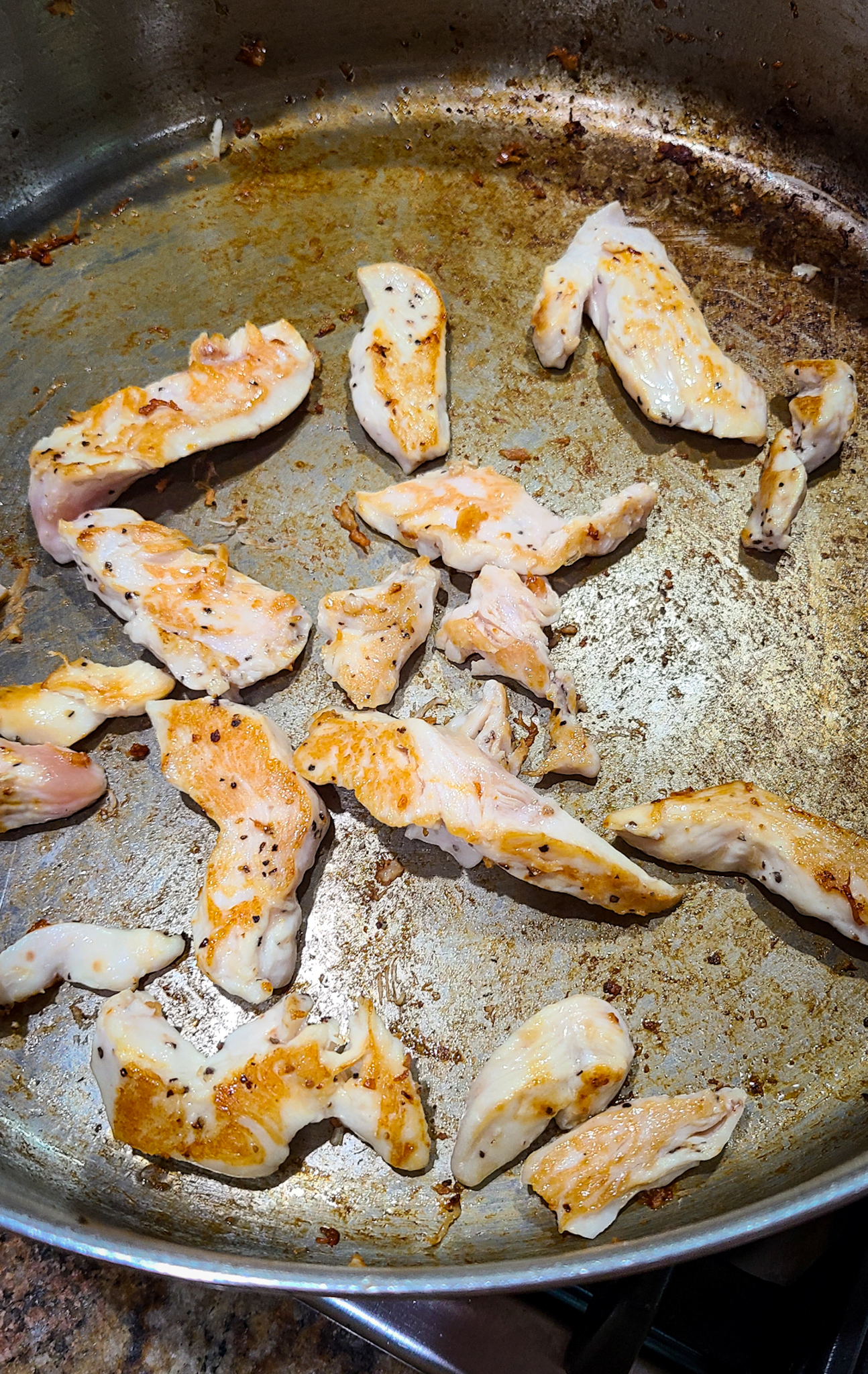 image of sliced seared chicken breast in stainless stell skillet