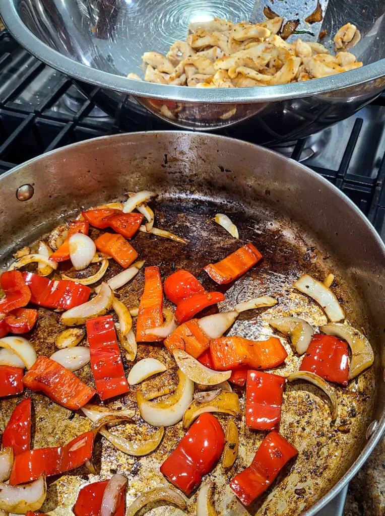 image of sauteed red bell peppers and onion browned in skillet for the purpose of making chicken and vegetable stir fry