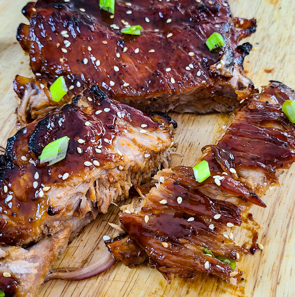 sliced ribs glazed with sticky sweet soy sauce on cutting board