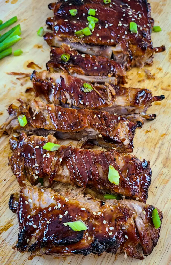 sliced ribs glazed with sticky sweet soy sauce on cutting board