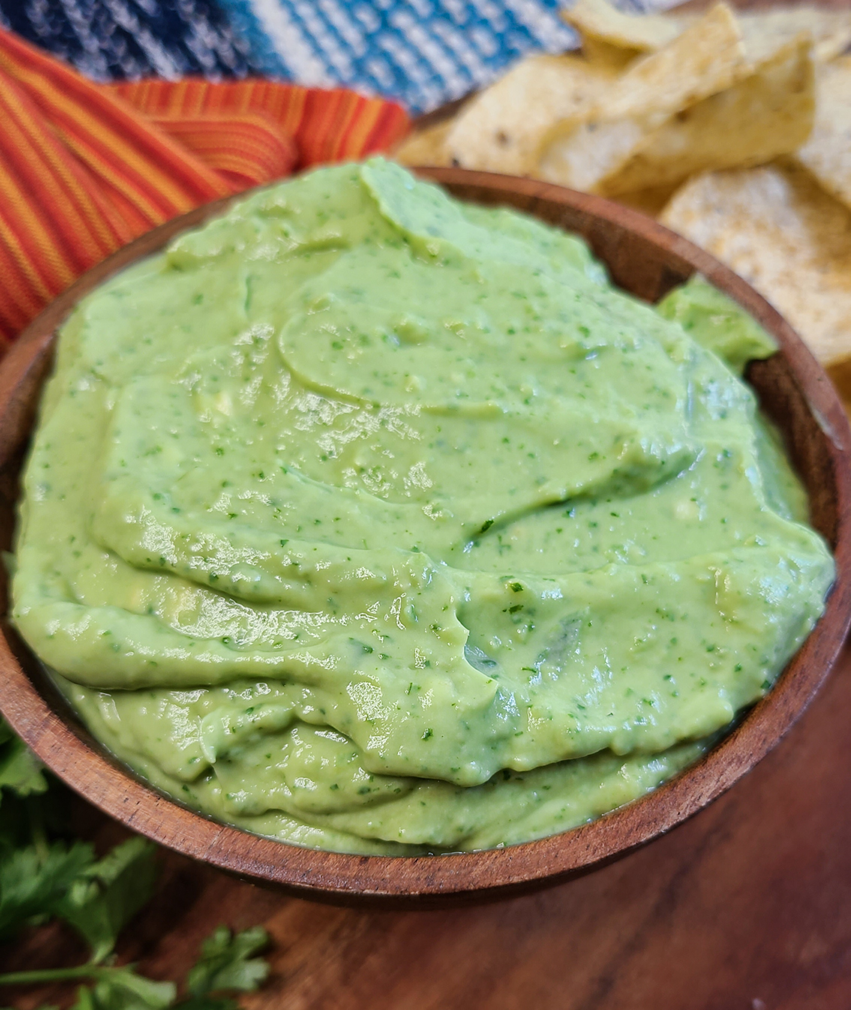 upclose image of creamy whipped guacamole dip in wooden bowl
