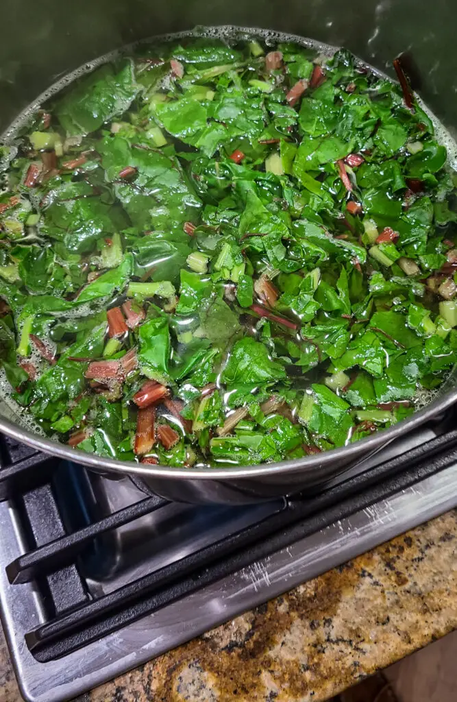 overhead image of swiss chard boiling in large pot of water