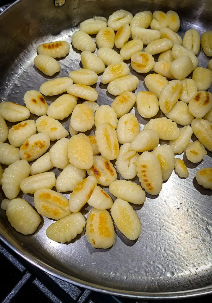 overhead image of potato gnocchi pan searing in a skillet