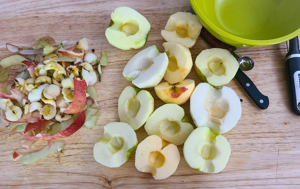 image of peeled and cored apples cut crosswise on wooden cutting board
