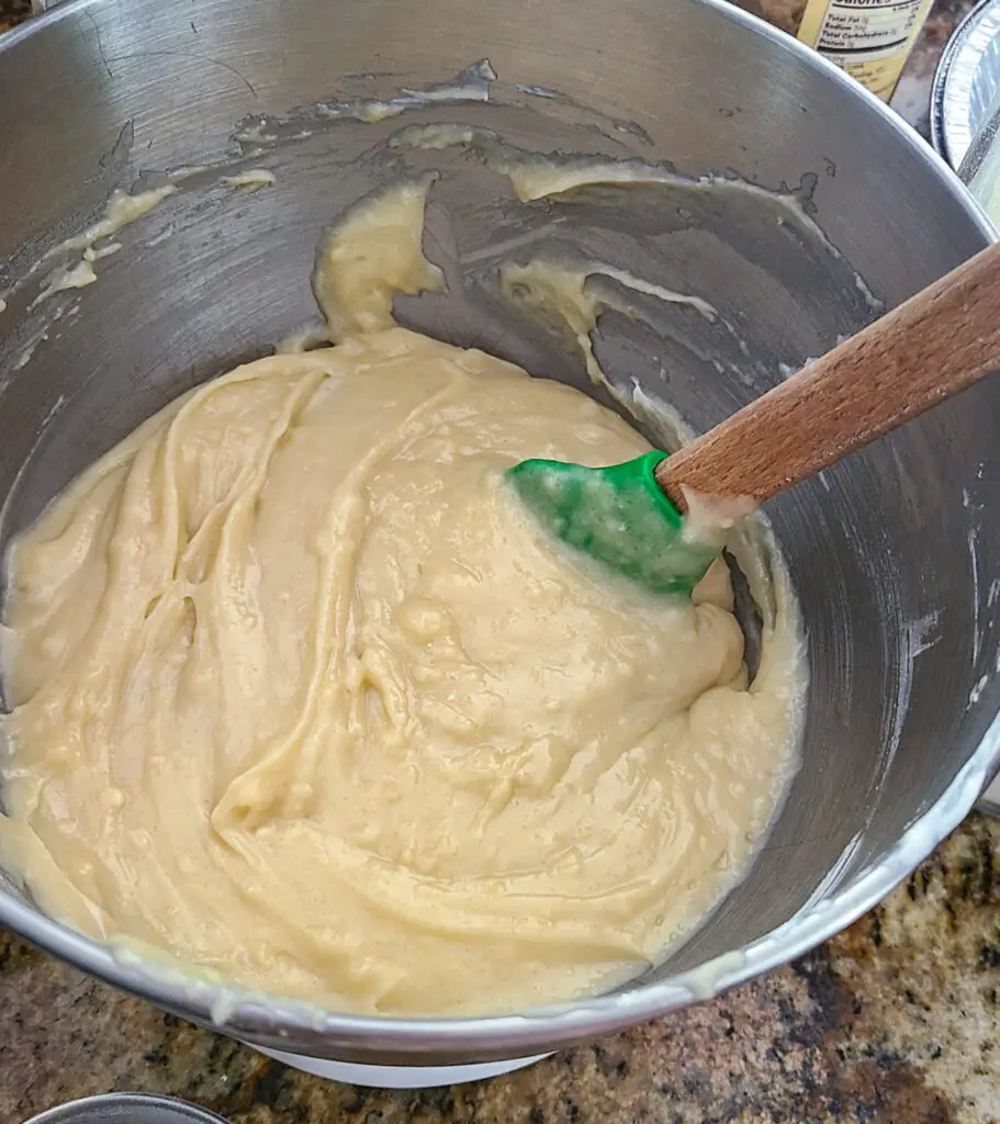 image of large mixing bowl with cake batter and spatula standing in batter