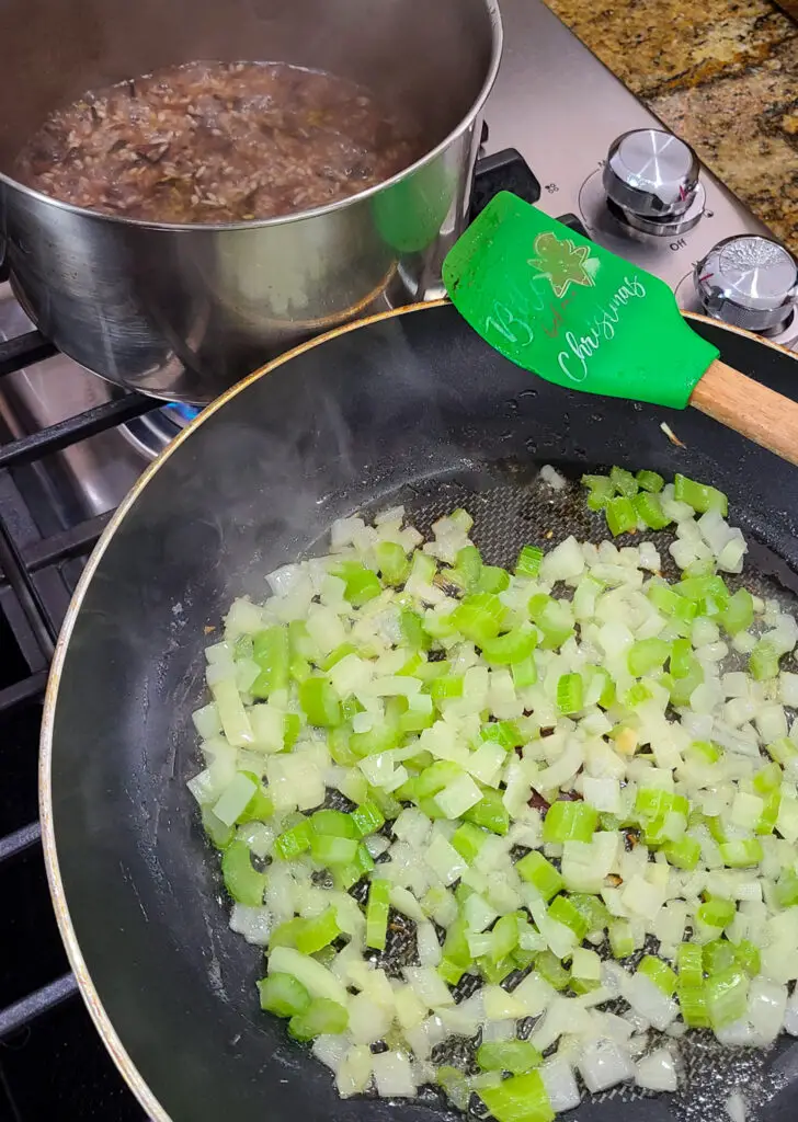 Rinse rice and cook according to package instructions. Melt butter in a skillet over medium heat and sauté onion and celery. Cook until softened and onions are translucent, about 5 minutes.