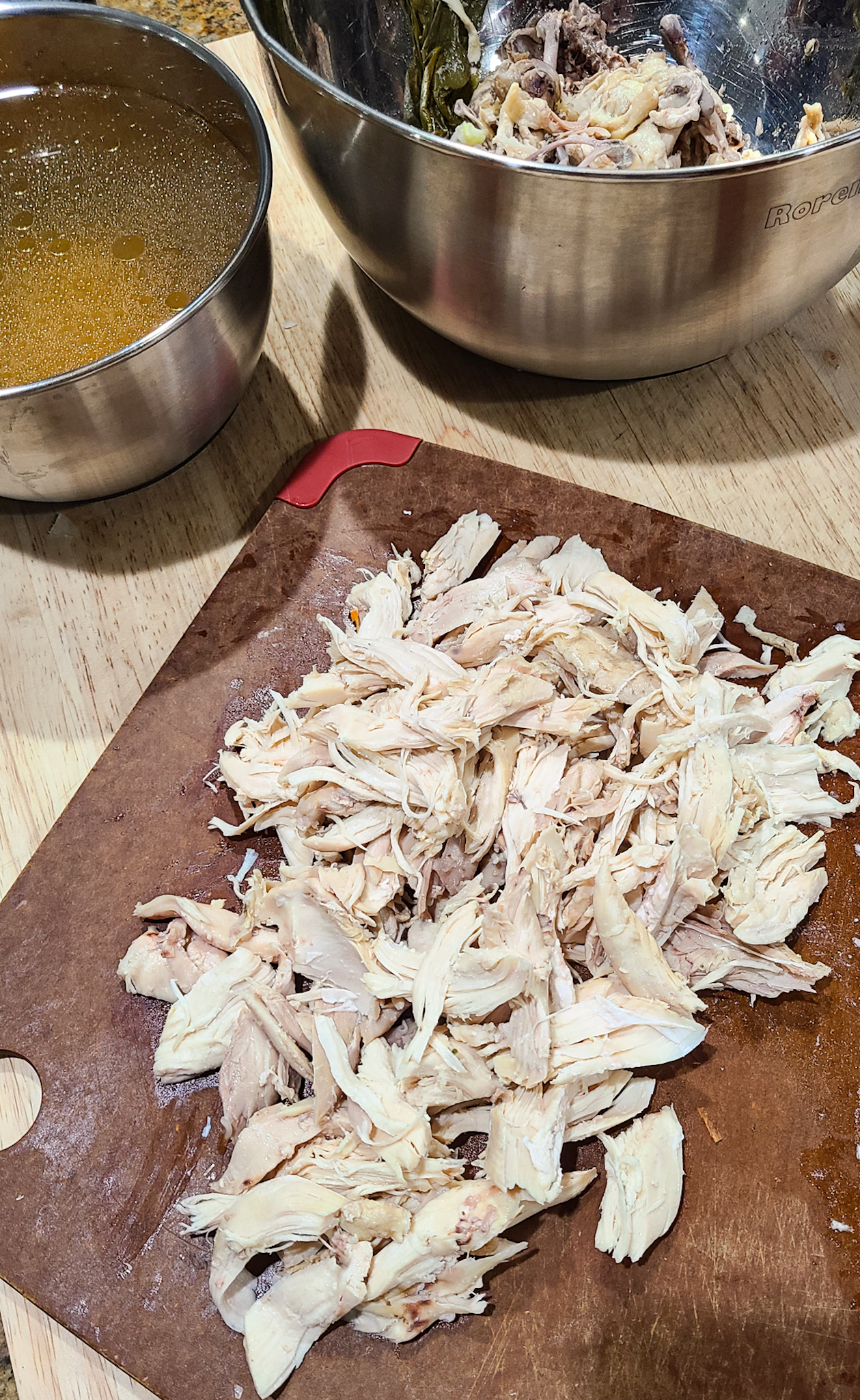 shredded chicken meat on cutting board