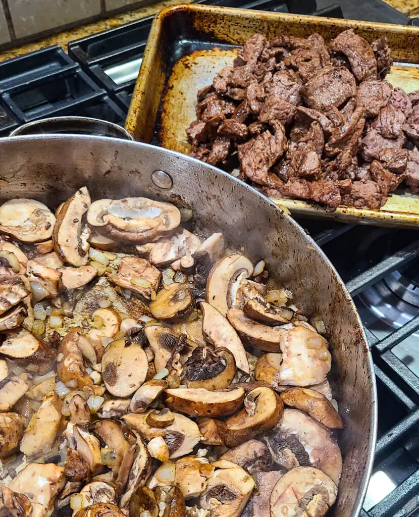 image of skillet containing sautéed mushrooms next to a pan of seared and sliced beef .