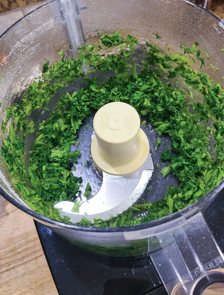 image of cooked broccoli rabe, pulsed in a food processor for purpose of showing steps of how to make Italian style meatloaf