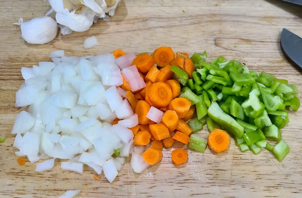 image of chopped onion, green pepper, and carrot on a cutting board