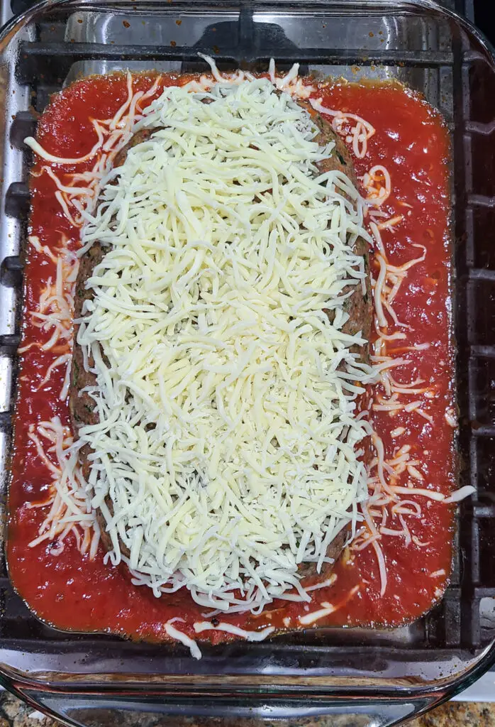 image of meatloaf with marinara sauce in baking dish with shredded mozzerella cheese. 