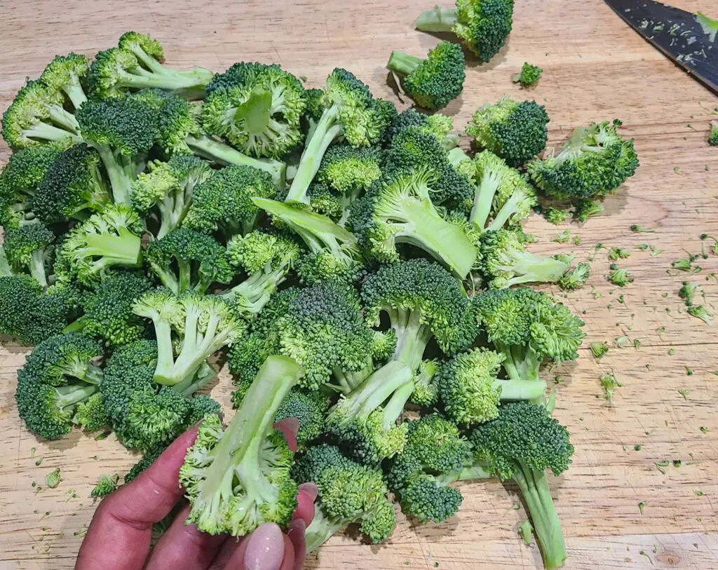 image of trimmed broccoli florets on cutting board in preparation of roasting in oven