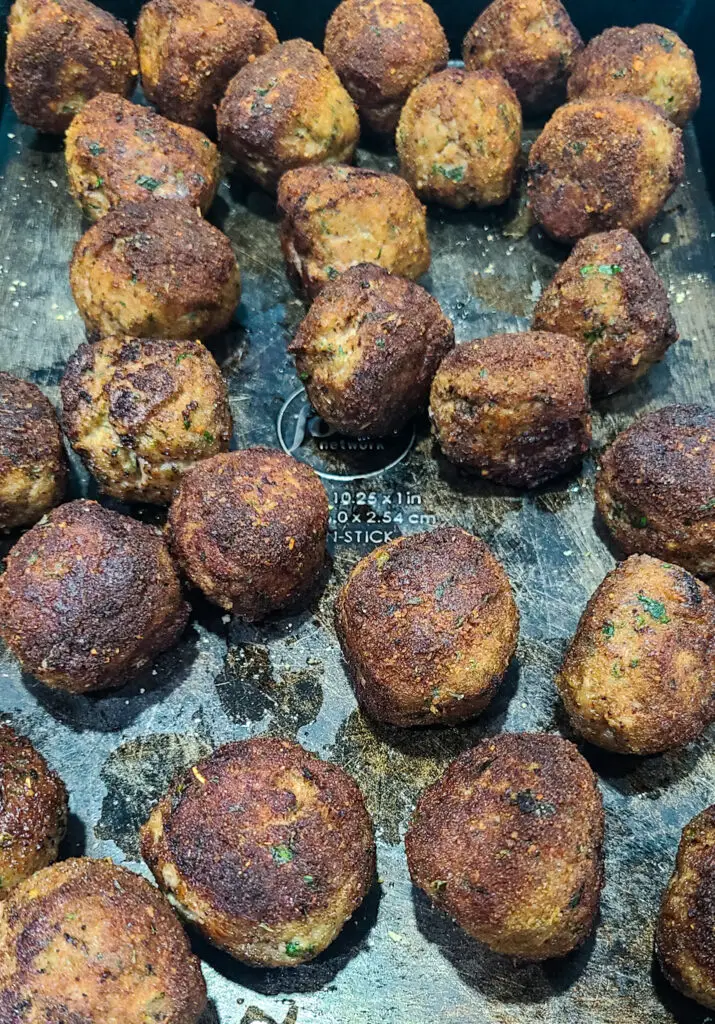 browned meatballs set on a baking sheet