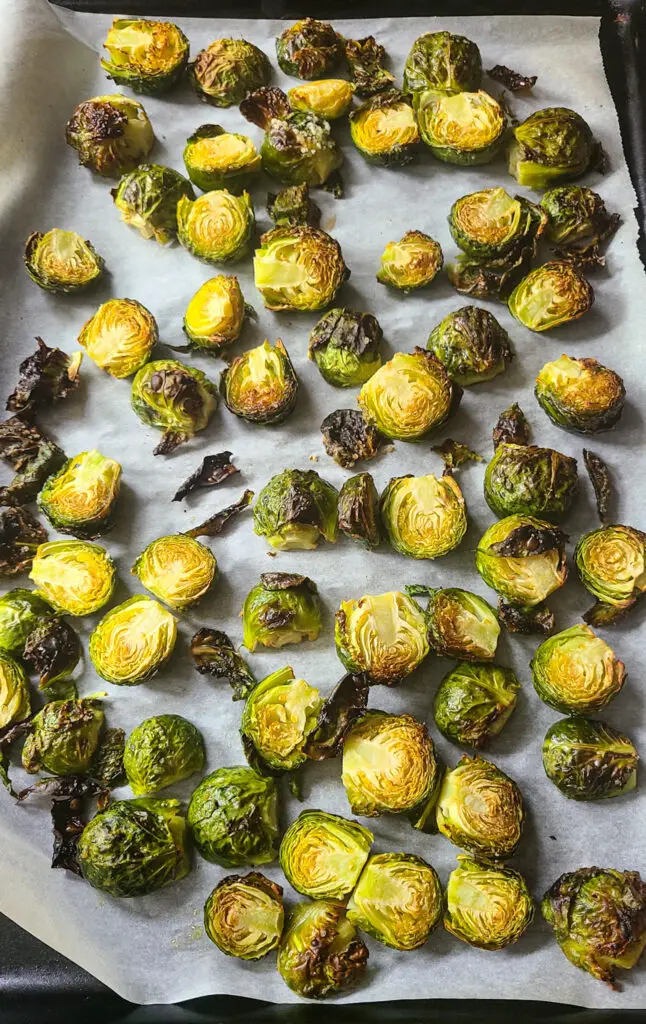 roasted halved brussels sprouts on parchment lined baking sheet